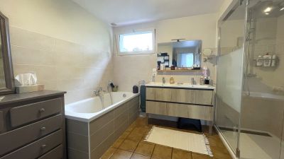 **Propriété à vendre avec salle de bains moderne** : Baignoire et douche à l'italienne.